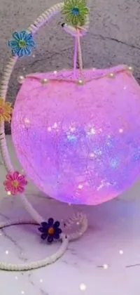 This phone live wallpaper features a pink purse with a light inside, surrounded by pastel colors and twinkling stars