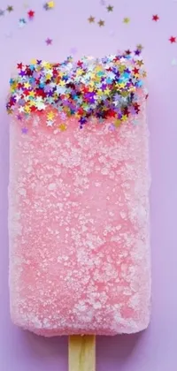 This phone live wallpaper features a vivid close-up of a popsicle on a stick covered in multicolored confetti sprinkles