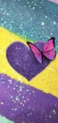 This phone live wallpaper features a vibrant pink butterfly perched atop a purple heart that glitters with sand and sparkles