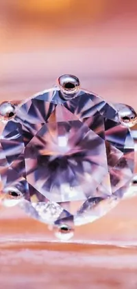 Set your phone aglow with this captivating live wallpaper featuring a stunning diamond ring resting on a table