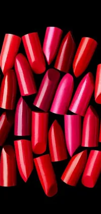 This lively and colorful phone wallpaper depicts a bright pile of red nail polish against a sleek black background