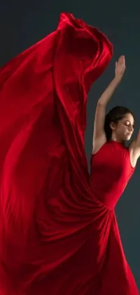 This mobile wallpaper features a captivating video still of a graceful woman, dressed in a vibrant red gown, dancing with poise and elegance