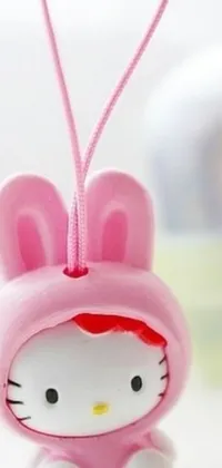 This live wallpaper features a close-up view of a Hello Kitty ornament in vibrant colors