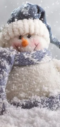 Experience the magic of winter on your phone with this charming live wallpaper featuring a snowman sitting atop a fresh pile of snow