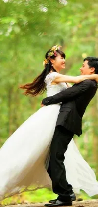 This phone live wallpaper depicts a romantic scene of a man and woman smiling and dancing in formal attire against a forest backdrop