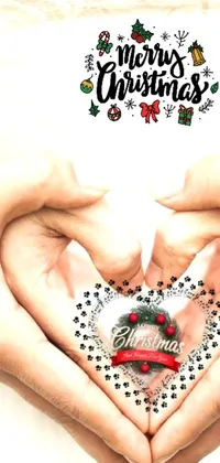 This live wallpaper showcases a loving heart gesture made with two hands against a background of warm, holiday-inspired imagery