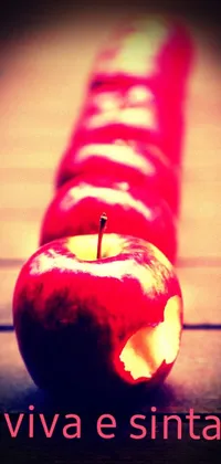 Showcase your love for healthy snacking with this stunning phone live wallpaper! Featuring a red apple placed atop a wooden table, this wallpaper is a perfect testament to the art of precisionism