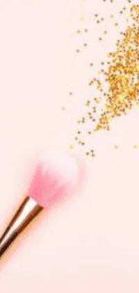 This phone live wallpaper is a sparkly pink makeup brush set against a light pink background and decorated with gold glitter