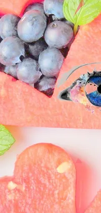 This phone live wallpaper depicts a plate of fresh blueberries surrounded by a digital art background