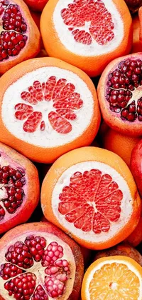 This lively phone live wallpaper features a pile of fragrant oranges and vibrant red pomegranates contrasted against a dynamic pixabay background in a pink and red color scheme