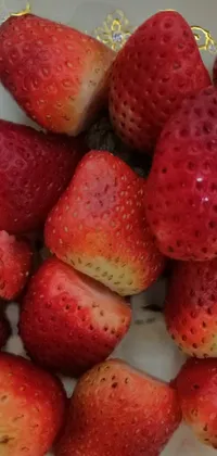 This phone live wallpaper depicts a stunning view of a plate filled with ripe and juicy strawberries, captured during a trip to Egypt