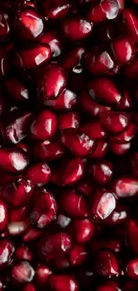 Get lost in the vivid beauty of this live wallpaper featuring a close-up of fresh, ripe pomegranate seeds with a deep, grainy texture and drops of juice like tiny jewels