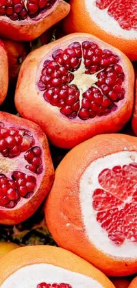 This phone live wallpaper features a striking pile of pomegranates in a vibrant patterned background