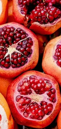 This live phone wallpaper showcases a vibrant pile of pomegranates set against a deep purple background