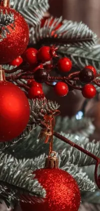 Decorate your phone for the holidays with this digital art live wallpaper of a Christmas tree with ornaments and berries