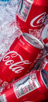 This live phone wallpaper features a pile of Coca Cola cans arranged in a pyramid-like shape on top of ice cubes