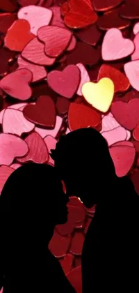 This animated live wallpaper features a romantic scene of a couple sharing a kiss in front of a sea of colorful hearts, creating an alluring and captivating atmosphere
