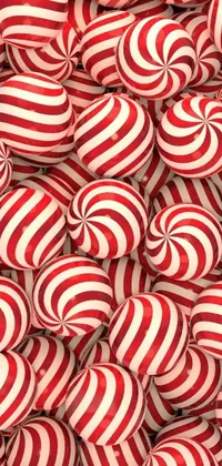 This phone live wallpaper features a playful design of red and white striped candy balls arranged in a mountain-like pile