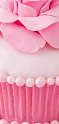 This live wallpaper features a captivating close-up view of a delectable cupcake adorned with a soft pink rose