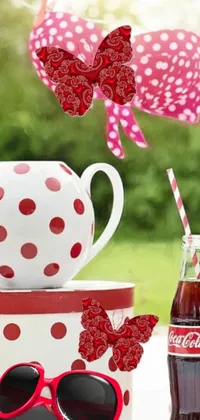 This vibrant phone live wallpaper features a red and white polka dot cup with a butterfly in a jar and Coca Cola bottle