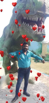 This live wallpaper features a man standing in front of a towering dinosaur statue in an amusement park