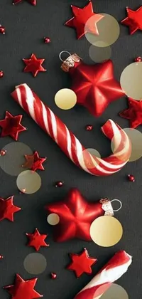 This live wallpaper for your phone features a stunning close-up of a shiny candy cane on a table, surrounded by beautiful organic ornaments