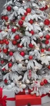 This smartphone live wallpaper depicts a stunning Christmas tree surrounded by gently falling snowflakes