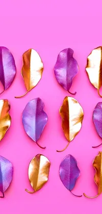 This live phone wallpaper showcases a gorgeous group of purple and gold leaves on a beautiful pink backdrop