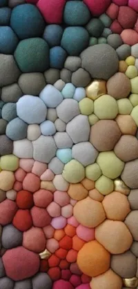 This phone live wallpaper boasts an intricate design of colorful rocks, neatly arranged on a wooden table