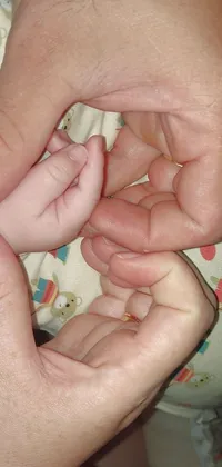 This heartwarming live wallpaper depicts a close-up image of a person holding a baby
