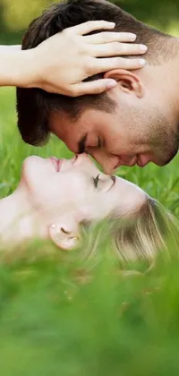 This live wallpaper for your phone features a beautiful romantic scene of a man and woman lying in the lush green grass