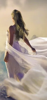 This phone live wallpaper showcases digital art of a woman in white dress standing on a mountain