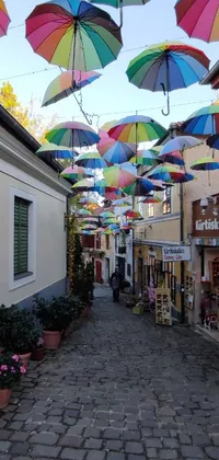 This phone live wallpaper transports you to a lively street scene with colorful umbrellas, street art, Transylvania, Biedermeier, and a cozy atmosphere reminiscent of Tlaquepaque in Mexico