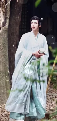 Experience a serene imagery with this blue kimono woman standing next to a tree