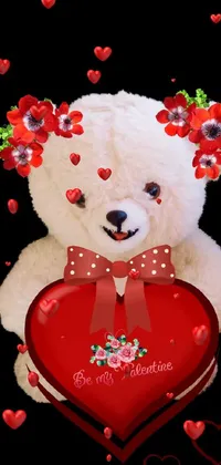 This phone live wallpaper features a cute, white teddy bear sitting on a grassy field surrounded by colorful flowers with a heart-shaped box clutched close to its chest