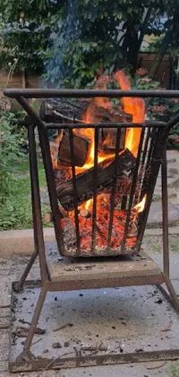 This phone live wallpaper showcases a cozy fire pit burning warmly in the center of a rustic backyard