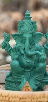 This lively phone wallpaper showcases an ornate turquoise statue of an elephant in a basket set against a jade green background