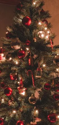 Get into the holiday spirit with this festive phone live wallpaper! Featuring a beautifully decorated Christmas tree adorned with shiny red and silver ornaments set against a warm brown background of a cozy living room with a fireplace, this wallpaper is the perfect addition to your device this season