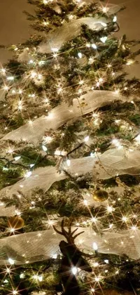 Bring the joy of the Christmas season to your phone with our stunning live wallpaper! Featuring a beautiful Christmas tree adorned with twinkling lights, elegant white ribbons, and shimmering stars in a close-up view, this live wallpaper will transform your phone's screen into a magical wonderland