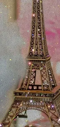 This phone live wallpaper depicts a stunning close-up of a figurine of the Eiffel Tower, created using the pointillism technique