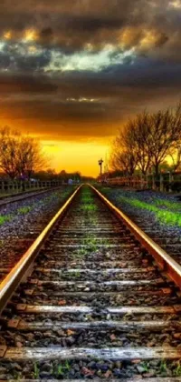 This mobile live wallpaper features a scenic train track set against a dazzling sunset
