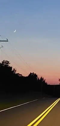 This live wallpaper features a street sign sitting beside a country road under a midnight sunset and pink moon