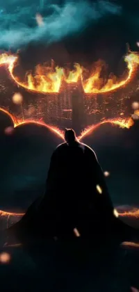 "Dark knight rises over city" live wallpaper depicts a dark and mysterious silhouette of a bat with its iconic ears overlooking the burning Gotham City at night in digital art form