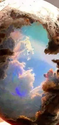 Experience a surreal portal to a metaphysical landscape with this stunning live wallpaper! Featuring dazzling digital art inspired by the Kim Keever style, this wallpaper showcases a hand holding a mesmerizing glass ball