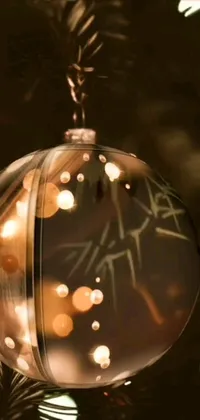Bring the magic of Christmas to your phone with this stunning live wallpaper featuring a close-up of a Christmas ornament on a tree