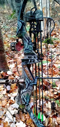 This captivating phone live wallpaper features a menacing bow and arrow lying on the ground in the woods