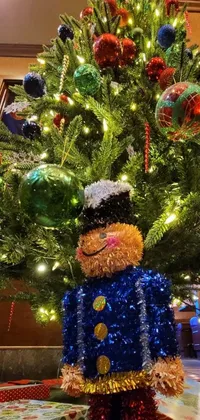 This stunning live wallpaper features a cute teddy bear sitting in front of a beautifully decorated Christmas tree