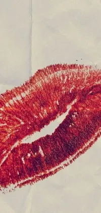 This phone live wallpaper features a close-up shot of a captivating red lipstick stain on paper