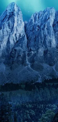 This stunning live wallpaper for your phone features a breathtaking landscape of a snow-covered mountain standing tall next to a lush forest