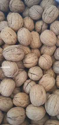 This live wallpaper features a stack of walnuts in varying shades of brown, set against an album cover in the background